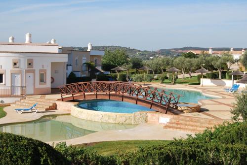 un puente sobre una piscina en un patio en Casa Campo & Mar, en Mexilhoeira Grande