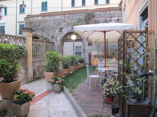 an outdoor patio with an umbrella and a table and chairs at Hotel Amalfitana in Pisa