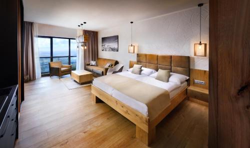 een hotelkamer met een groot bed en een stoel bij APLEND Monte Móry in Štrbské Pleso