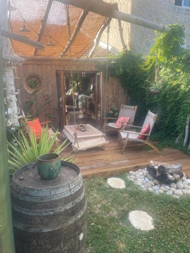 un patio con 2 sillas y un barril en la Kahutte, en La Rochelle