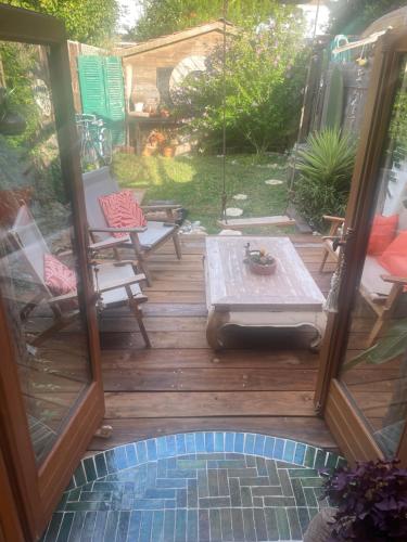 un patio con mesa y sillas en una terraza en la Kahutte, en La Rochelle