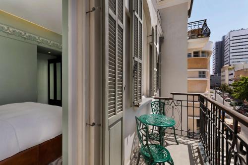 balcone con letto, tavolo e sedie di Bachar House a Tel Aviv