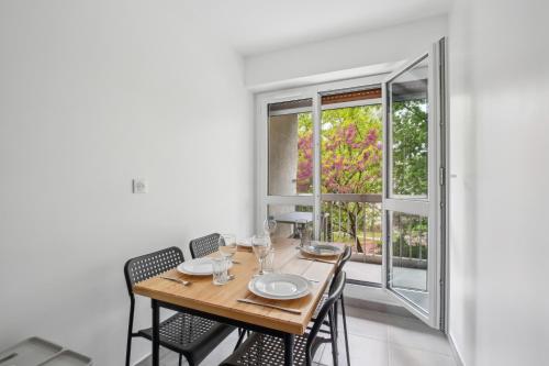 een eetkamer met een tafel en stoelen en een raam bij Duplex apartment downtown with parking in Cergy