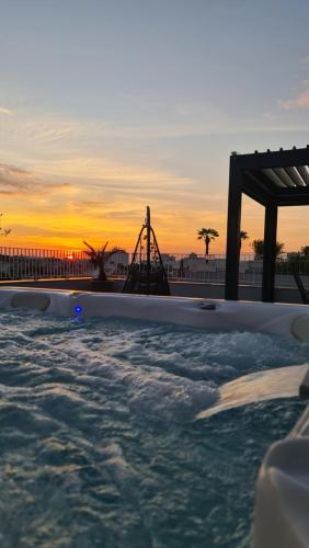 uma banheira de hidromassagem com uma base para copos ao fundo em Zadar Sunset Penthouse with spectacular view and jacuzzi em Zadar