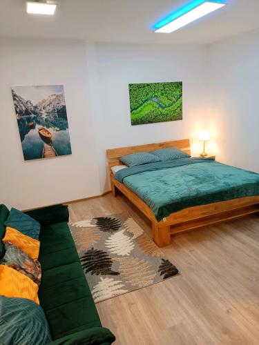 1 dormitorio con 1 cama y 1 sofá en Apartments Romantic and Family Room Zemlinski, en Payerbach