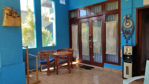 une chambre bleue avec une table et deux chaises dans l'établissement Bamboo Paradise, à Padangbai