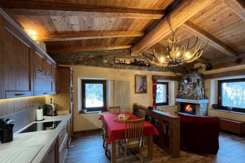 a kitchen with a table and a dining room at Chalet Chez Louis - Alpine Charm with Mont Blanc View & Ski Access in Courmayeur