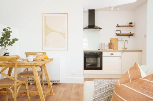 cocina con mesa de madera y comedor en Coastal Hideout, en Newquay