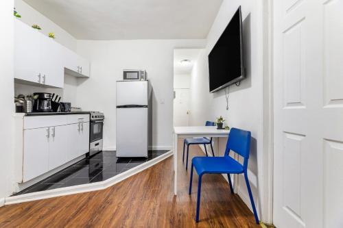 La cuisine est équipée d'une table, de deux chaises et d'un réfrigérateur. dans l'établissement Hidden Cozy 2BD apartment In Manhattan, à New York