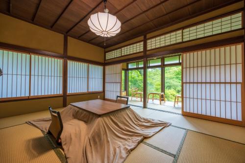 een kamer met een tafel in een kamer met ramen bij Matsuzakaya Honten in Hakone