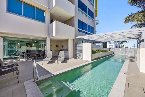 an exterior view of a house with a swimming pool at Nova Mooloolaba Beach Apartments in Mooloolaba