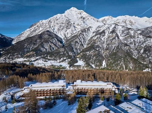 チェザーナ・トリネーゼにあるHotel Sansicario Majesticの雪山前のリゾートの空中風景