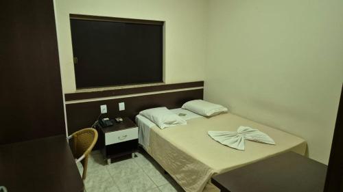 - une petite chambre avec un lit et une télévision dans l'établissement Dourados Center Hotel, à Dourados