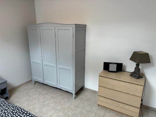 a bedroom with a white cabinet and a lamp on a dresser at Chambre de la Wamme 2 in Marche-en-Famenne