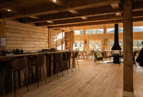 eine Bar mit Hockern in einem Zimmer mit Holzwänden in der Unterkunft Auberge Boréale de Charlevoix in Petit-Saguenay