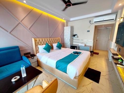 um quarto com uma cama grande e um sofá azul em SEA VIEW HOTEL DREAMLAND PURI -হোটেল ড্রিমল্যান্ড পুরী Rooms-sea view fully-air-conditioned-hotel with-lift-Restaurant-and-parking-facility - New marine Drive Road - Book Now em Puri