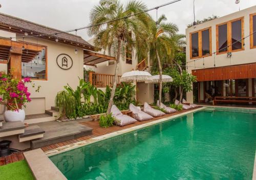 una villa con piscina e una casa di Nyaman Hostel a Canggu