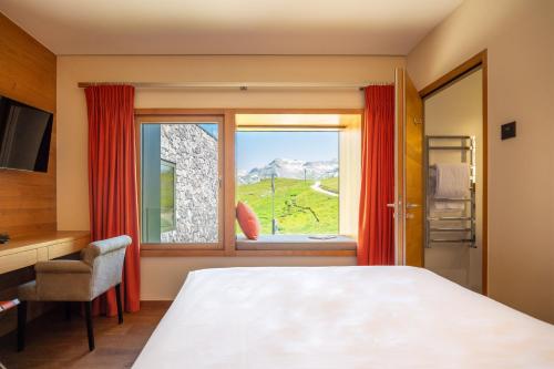 een slaapkamer met een bed en een raam met uitzicht bij chetzeron in Crans-Montana