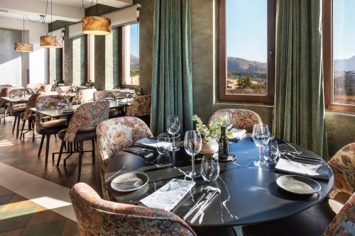 een eetkamer met tafels, stoelen en ramen bij Catalonia Ronda in Ronda