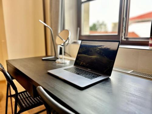 einen Laptop auf einem Holztisch in der Unterkunft Historical City Center apartment in Komárno