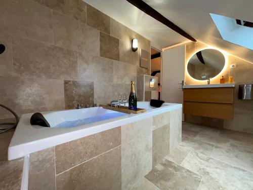 bagno con ampia vasca e bottiglia di champagne di Le Gatsby - COSY FLAT Hyper-Centre Senlis a Senlis