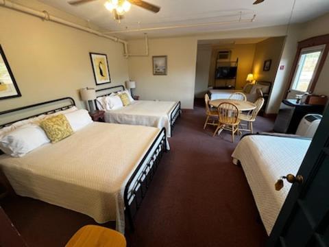 a hotel room with two beds and a table at Gifford House in Provincetown