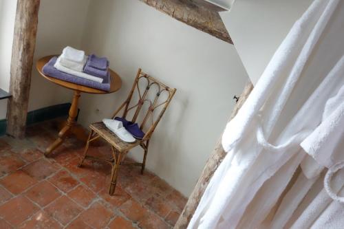 a room with a chair and a table with towels at La Passiflore B&B in Bossière