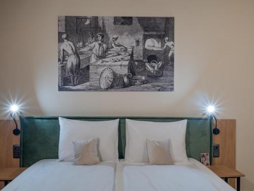 uma cama com duas almofadas e um quadro por cima em Craft Inn - Boutique Hotel em Sibiu