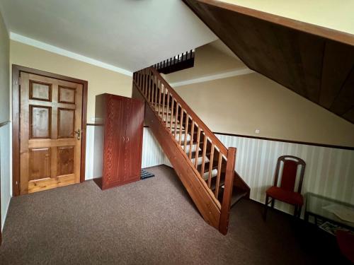 escalera de madera con puerta de madera y silla roja en Villa Daniela, en Úvaly