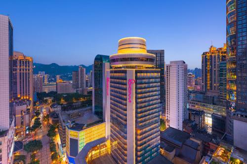 un grand bâtiment éclairé dans une ville dans l'établissement Moxy Chongqing, à Chongqing