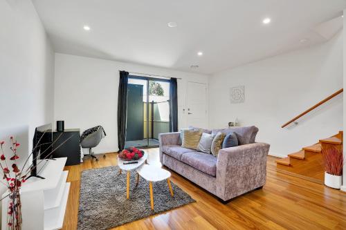 a living room with a couch and a table at Cozy Townhouse in Werribee centre in Werribee