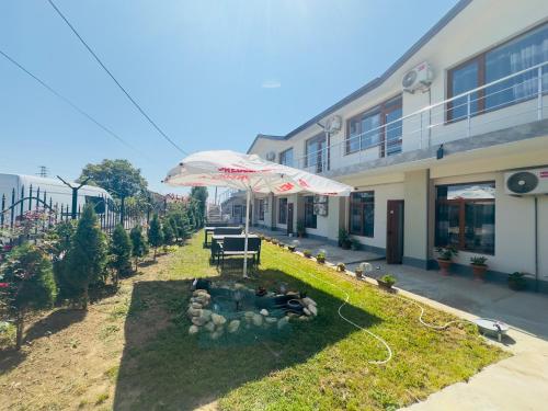 un jardín con sombrilla frente a un edificio en Стаи за гости Ася, en Kavarna