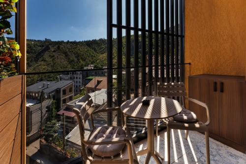 a patio with a table and chairs on a balcony at Solridge Aparthotel in Tbilisi City