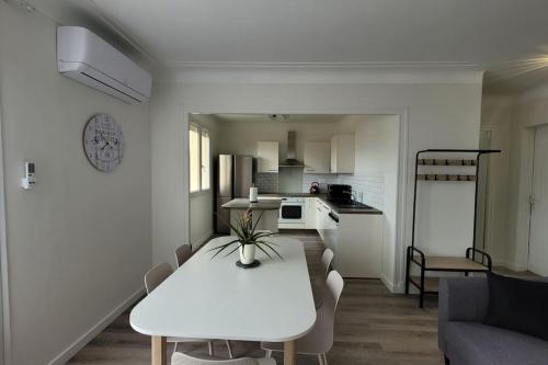 un soggiorno bianco con tavolo e cucina di BEL appartement T5 NEUF avec 4 chambres a Tarbes