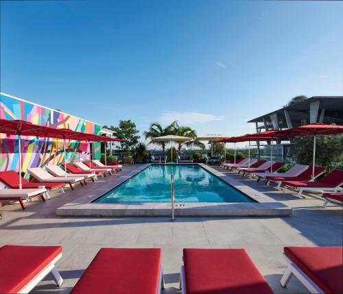 een zwembad met ligstoelen en parasols bij citizenM Miami South Beach in Miami Beach