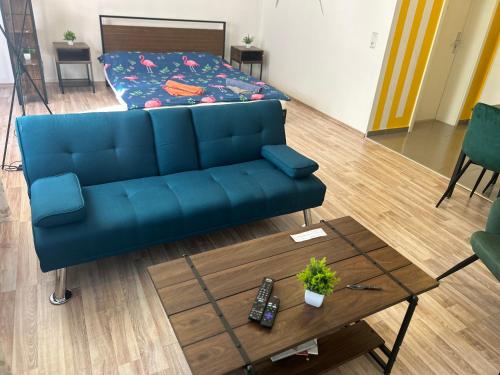 a living room with a blue couch and a coffee table at Piano Apartment Halle - Netflix - Free WiFi 4 in Halle an der Saale