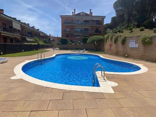 una piscina in un cortile con un edificio di Apartamento Loft, LLoret de Mar a Lloret de Mar