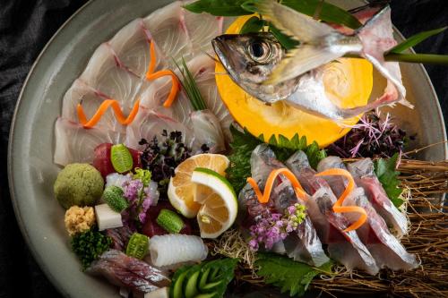 um prato de comida com peixe e legumes em Bessou Konjakuan em Yufu