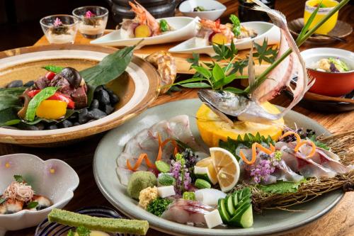 uma mesa de madeira com pratos de comida em Bessou Konjakuan em Yufu