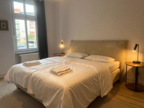 - une chambre avec un lit blanc et des serviettes dans l'établissement Maximi Loft - Ferien & Business, à Merseburg