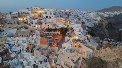 une vue aérienne sur une ville avec des bâtiments blancs dans l'établissement Art Maisons Oia Castle, à Oia