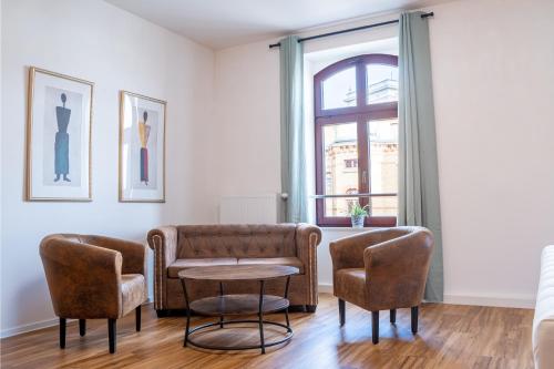 a living room with a couch and chairs and a table at Gwuni Mopera in Leipzig