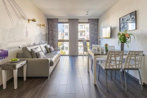 een woonkamer met een bank en een tafel bij Lagrange Aparthotel Lyon Lumière in Lyon