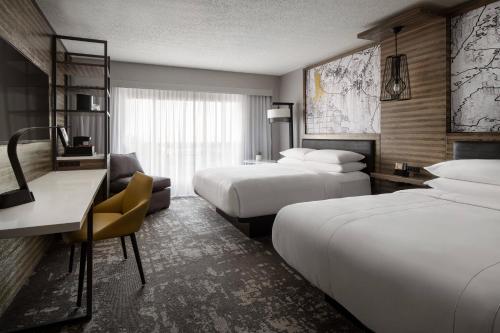 Cette chambre comprend deux lits et un bureau. dans l'établissement Marriott Indianapolis North, à Indianapolis