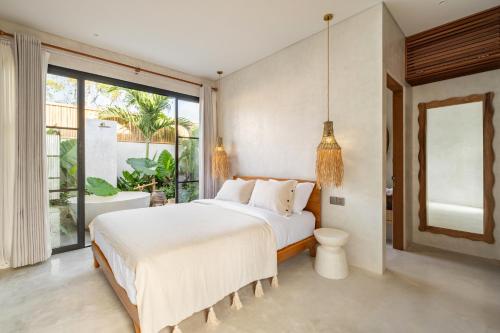 - une chambre avec un grand lit et une grande fenêtre dans l'établissement Alma Bingin Boutique Hotel, à Uluwatu