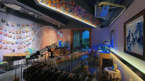 a stage with a telescope in a room with chairs at Dao Bian Inn in Zhangjiajie