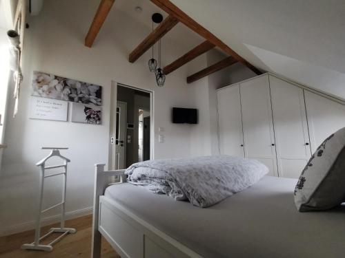 a white bedroom with a bed and a tv at Schwarzwaldpanorama Doppelzimmer-WC in Ettlingen