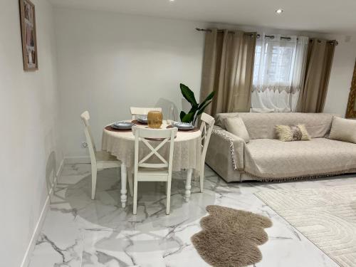 ein Wohnzimmer mit einem Tisch und einem Sofa in der Unterkunft Logement lina - proche paris et Orly in Palaiseau