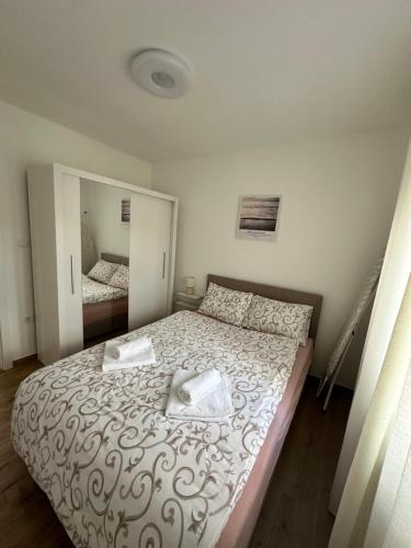 a bedroom with a large bed with a mirror at Apartment Athens in Sombor