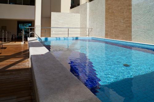 - une piscine d'eau bleue dans un bâtiment dans l'établissement Alameda Vitória Hotel, à Vitória